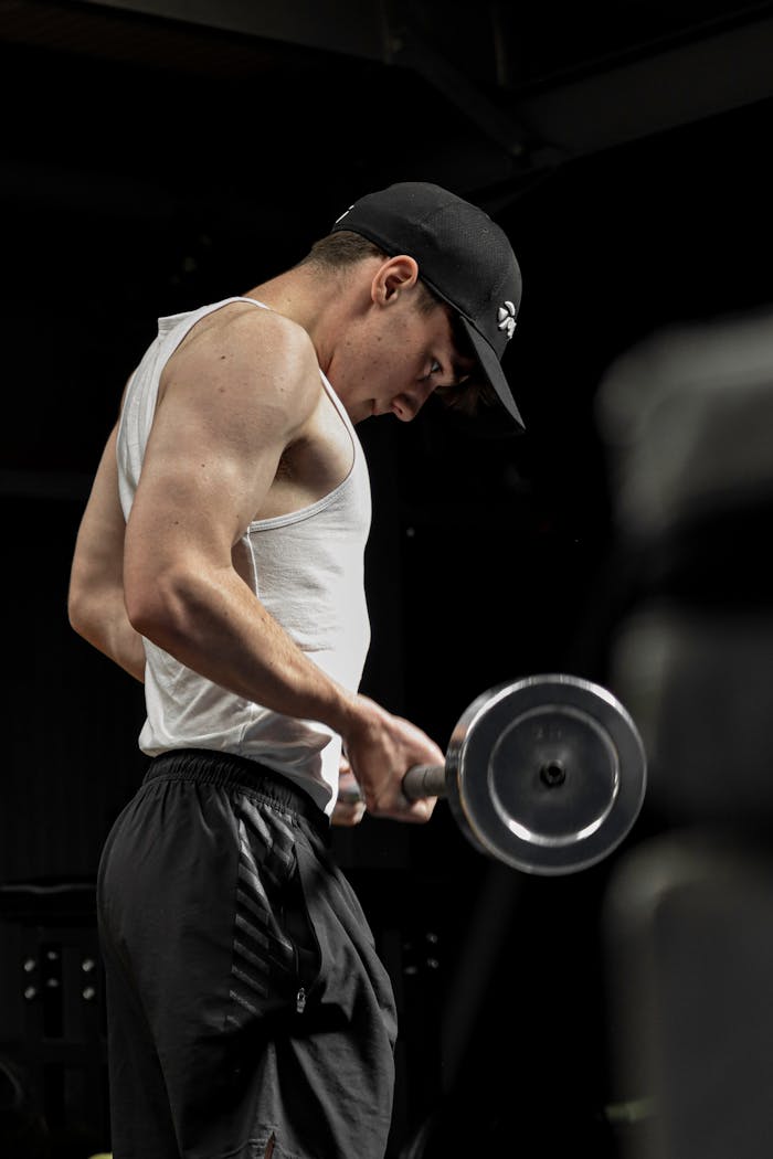 who-we-are Focused young man working out with dumbbells in the gym.
